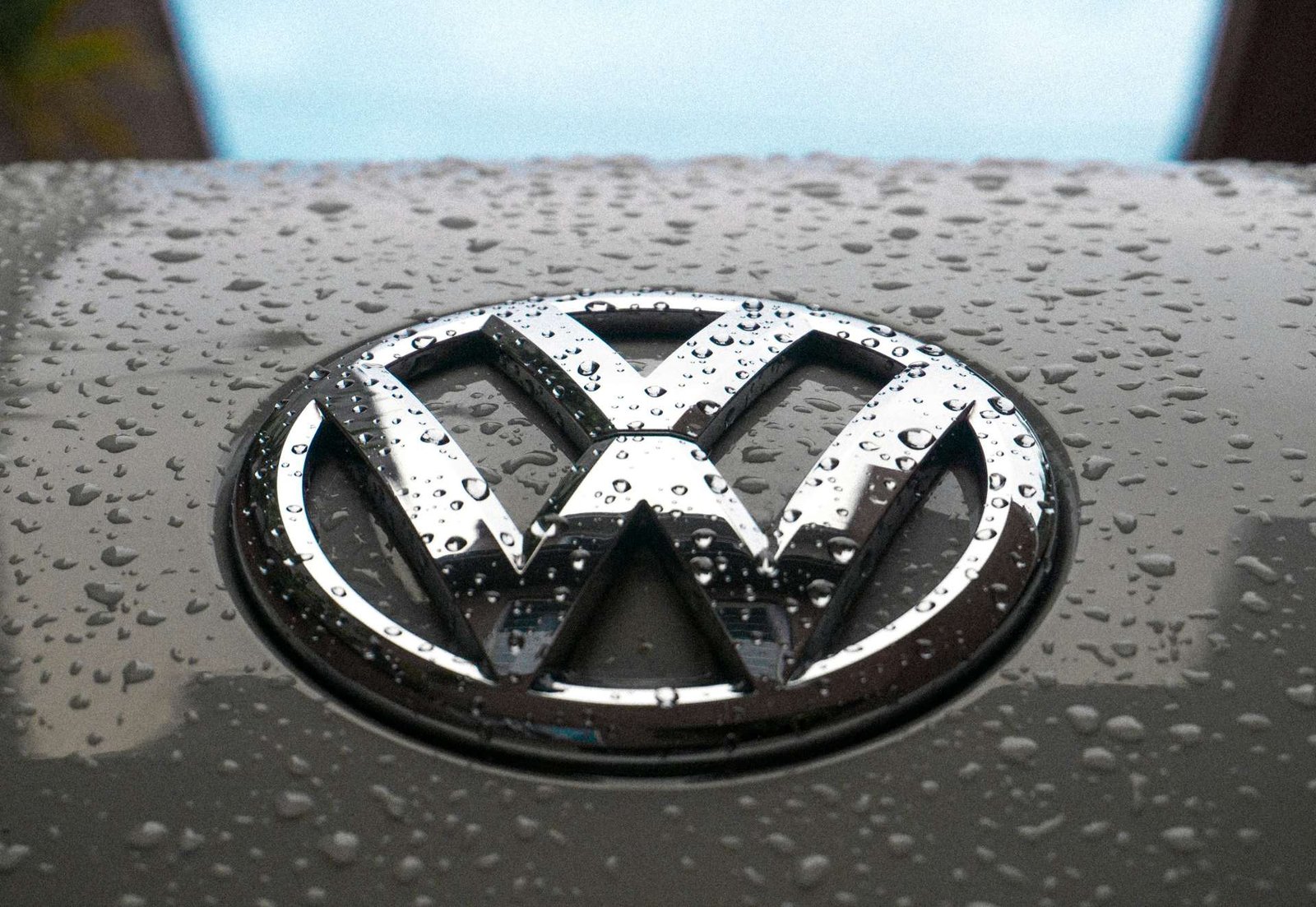 Chrome Volkswagen badge covered in rain drops